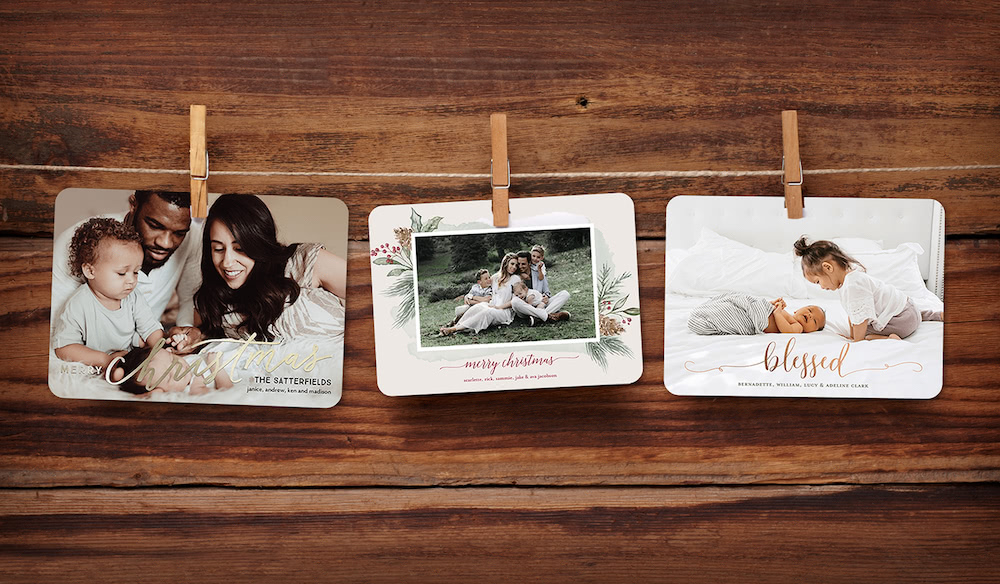 Hanging display of tinyprints personalized christmas cards on a wooden background