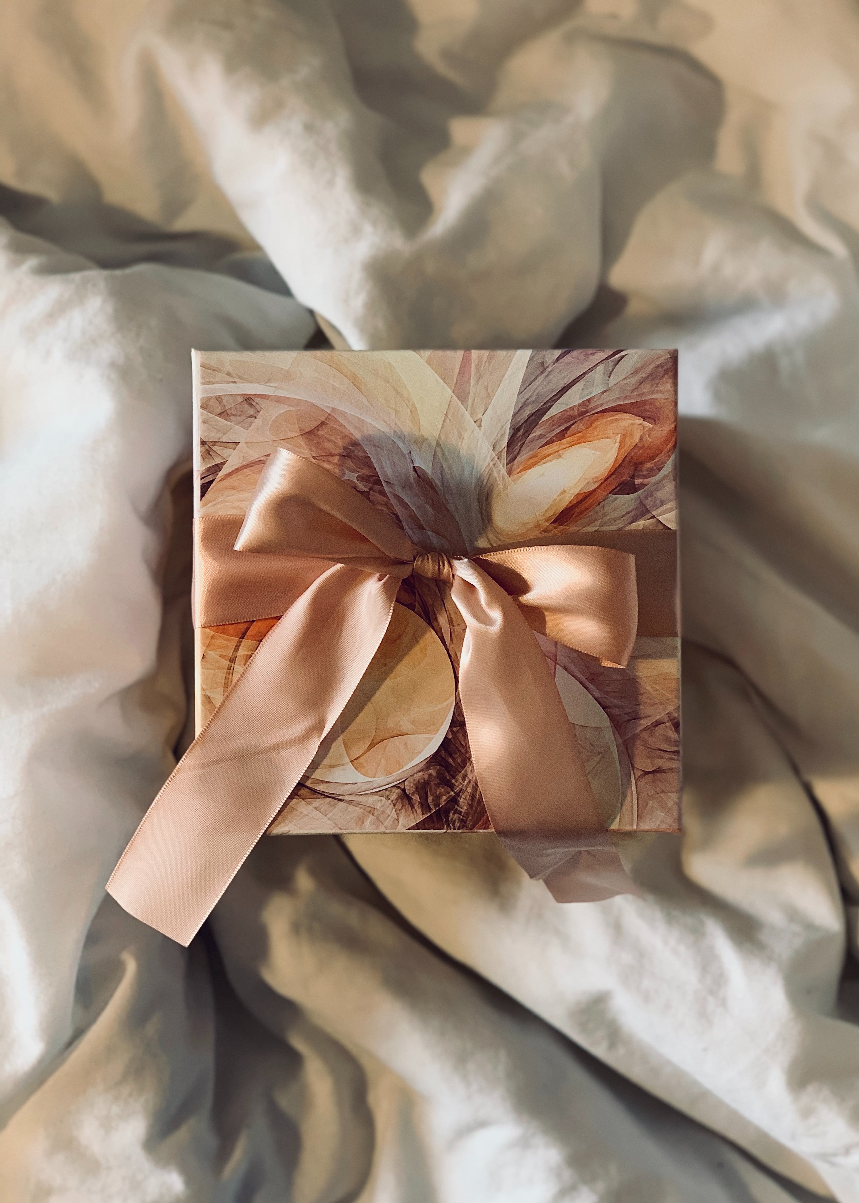 Brown and orange baptism gift box resting on a white sheet